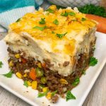 A slice of shepherd's pie with layers of meat, vegetables, and mashed potatoes